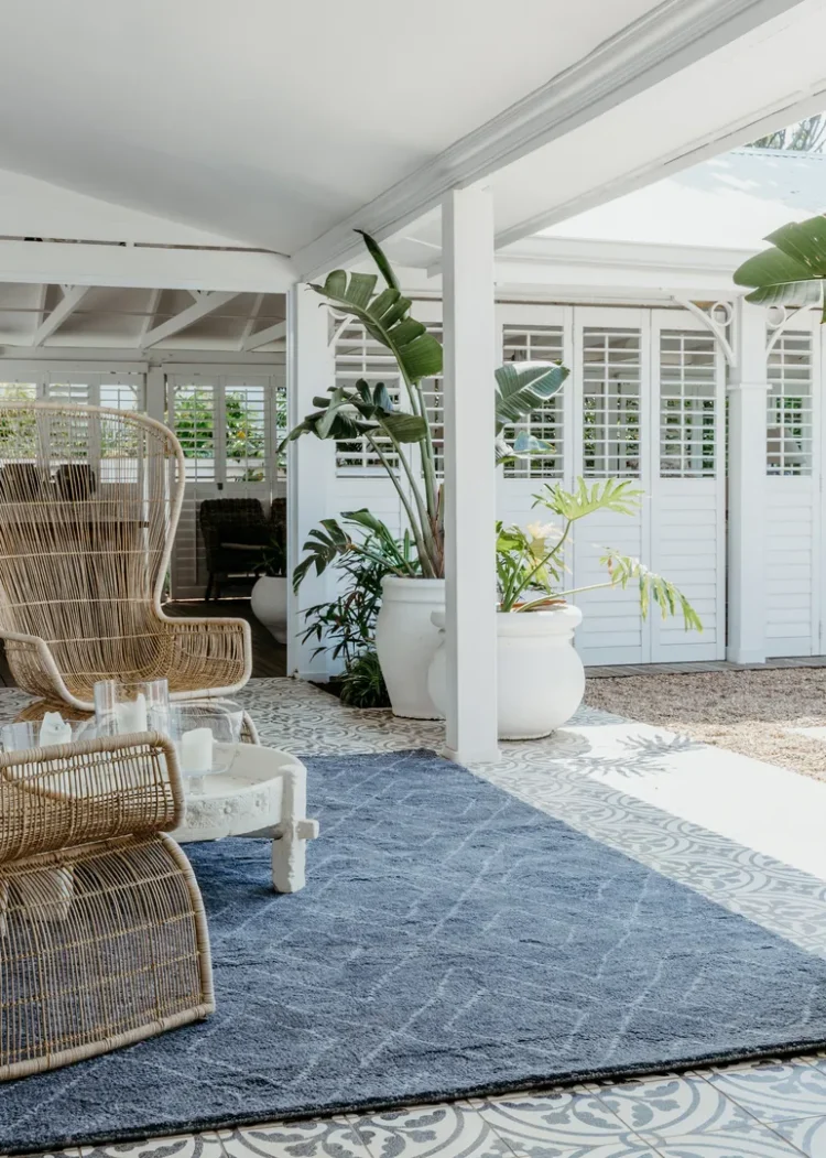 a patio with chairs and a lingala dark rug