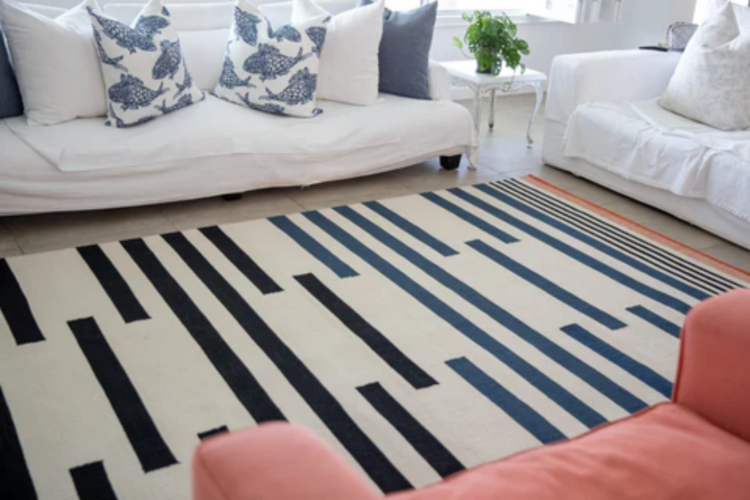 cream rug with thick black lines on the floor in living room